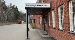 Röd tegelbyggnad, en skylt ovanför ingången med texten Kämpingeskolan.