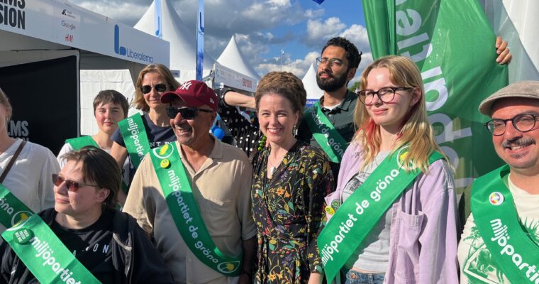 Amanda Lind omgiven av glada miljöpartister på Järvaveckan.