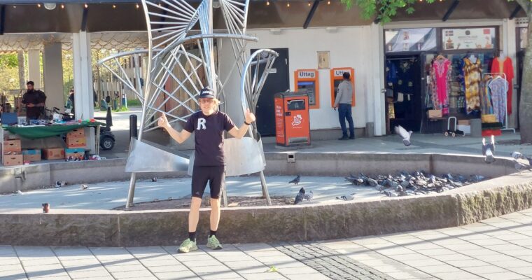 Man som står framför fontänen på Rinkeby torg.