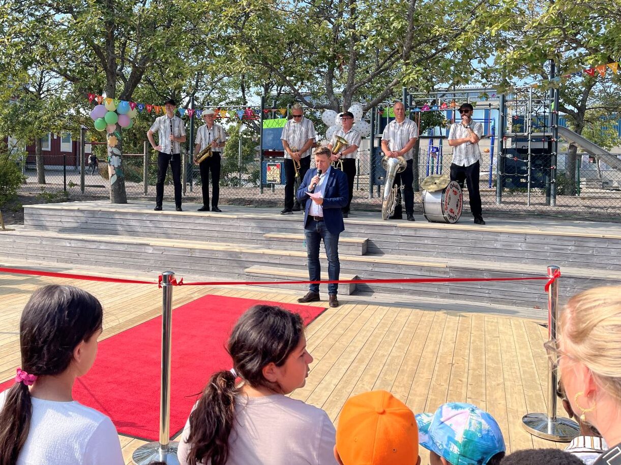 rektor talar på invigning bakom röda band och röd matta