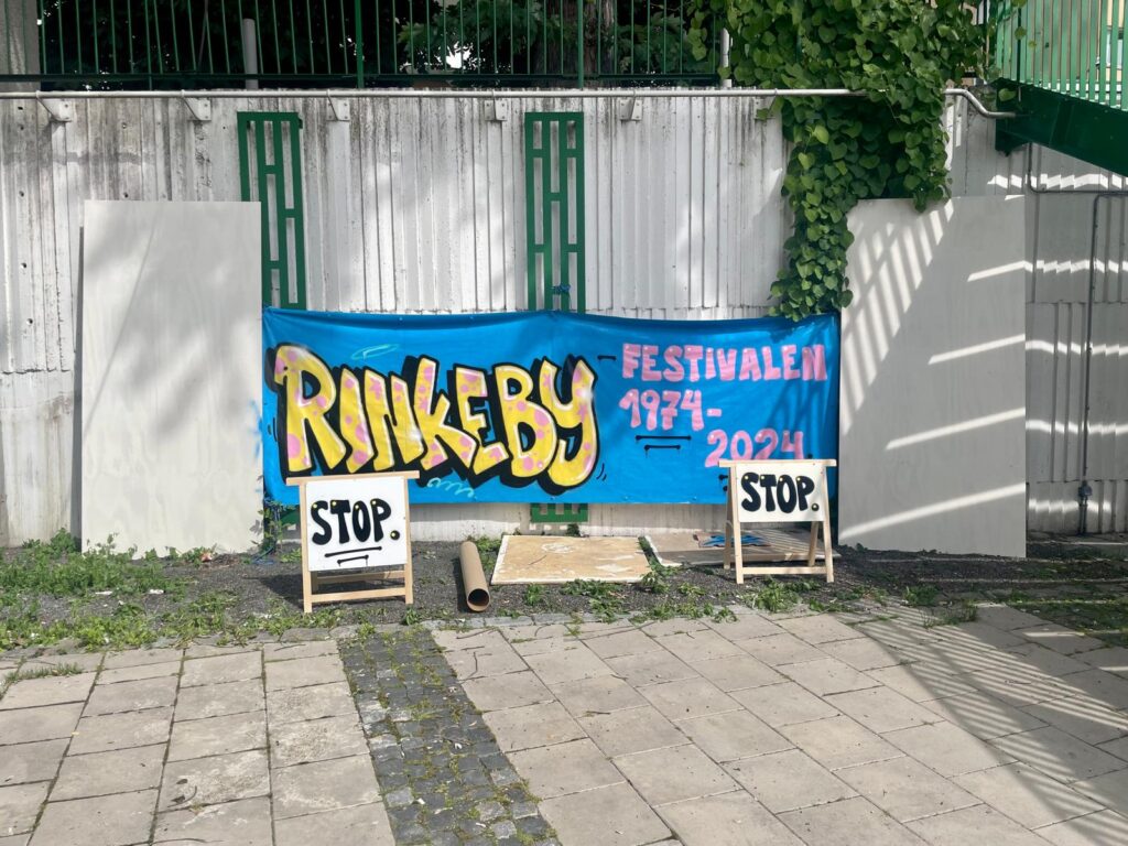 En graffititmålning som hänger för att torka, på den står det Rinkebyfestivalen 1974-2024