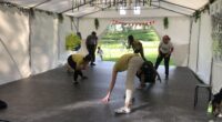 Några dansar capoeira i ett tält.