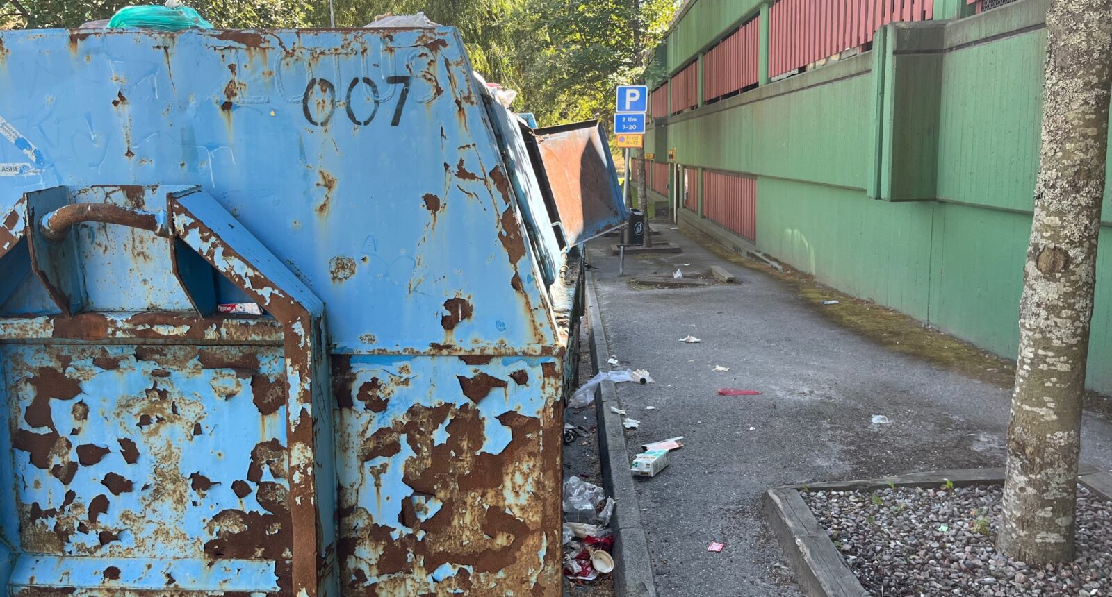 En container med sopor, även utanför den.