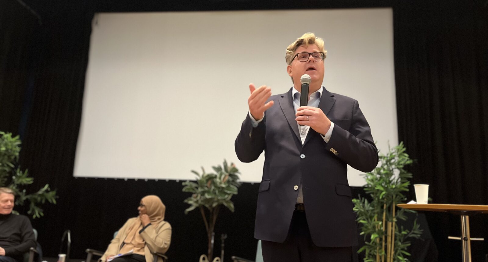 Justitieminister Gunnar Strömmer (m) talar i mikrofon på en scen.