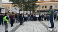 demonstranter med skyltar emot slöjförbud på ett torg