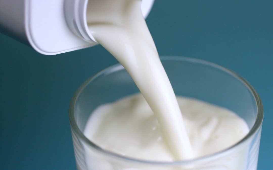 hælder mælk fra karton til glas
