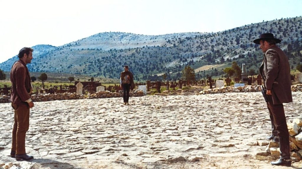 Three men in a desolate landscape.