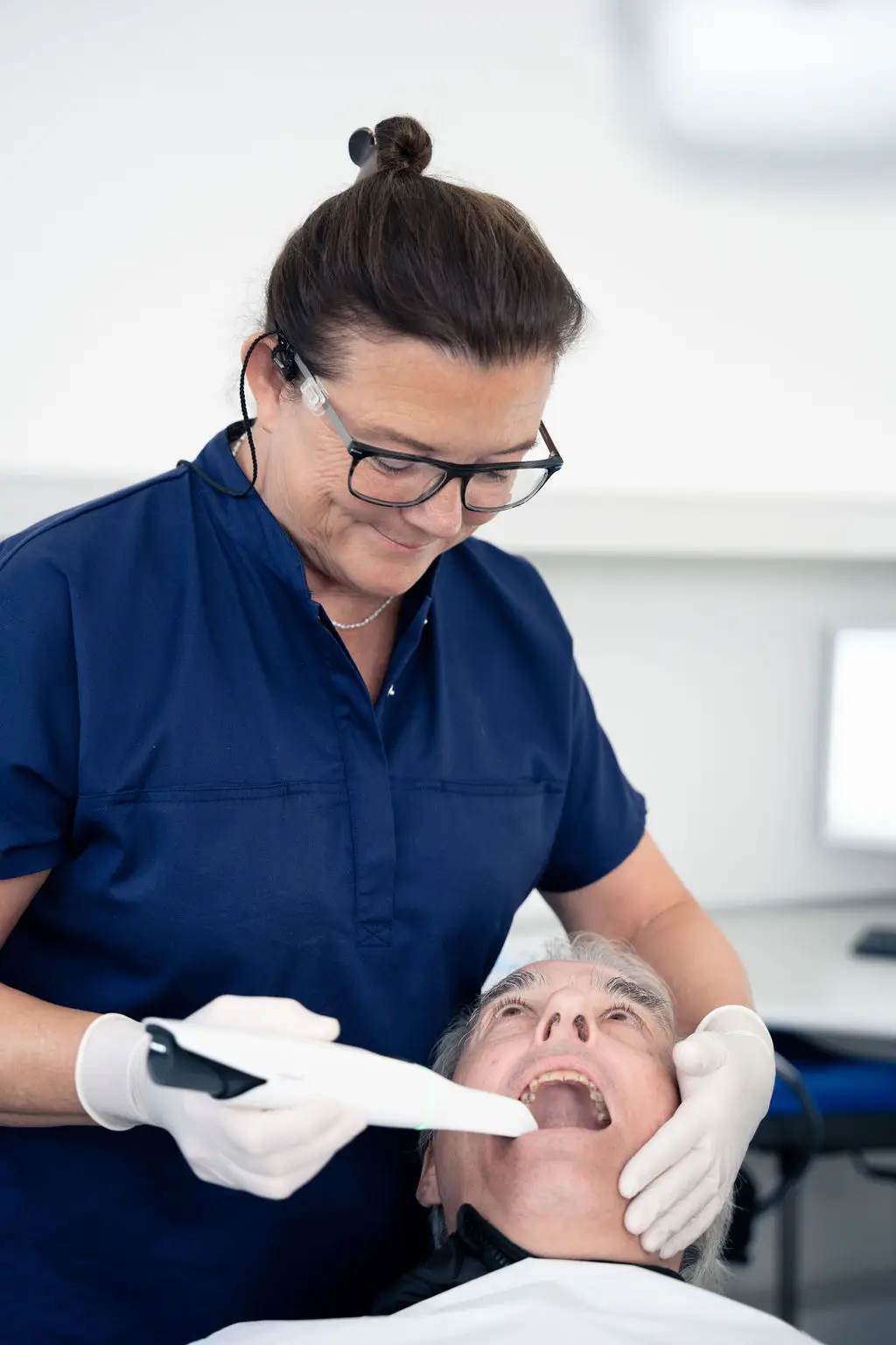 Tandlæge udfører undersøgelse af ældre patient i klinik på Amager