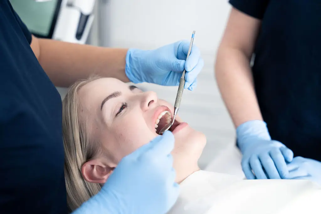 Tandlæge udfører undersøgelse af kvindelig patient hos Tandlægerne Ølandshus