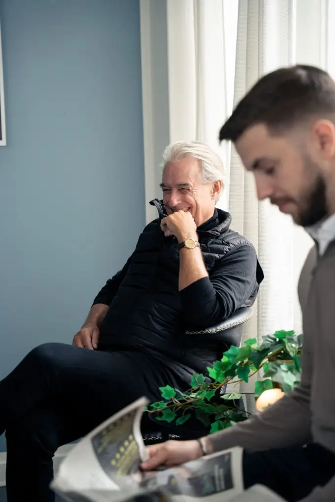 Ældre mand smiler i venteområde hos tandlægeklinik på Amager