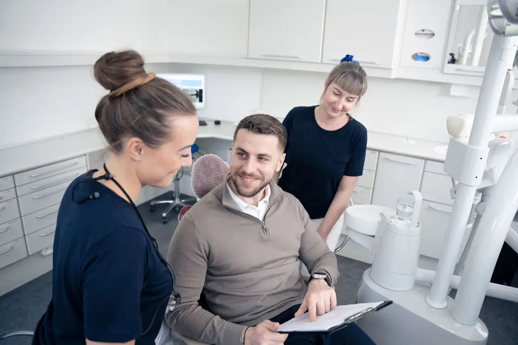 Patient og personale gennemgår information efter behandling hos tandlæge på Amager