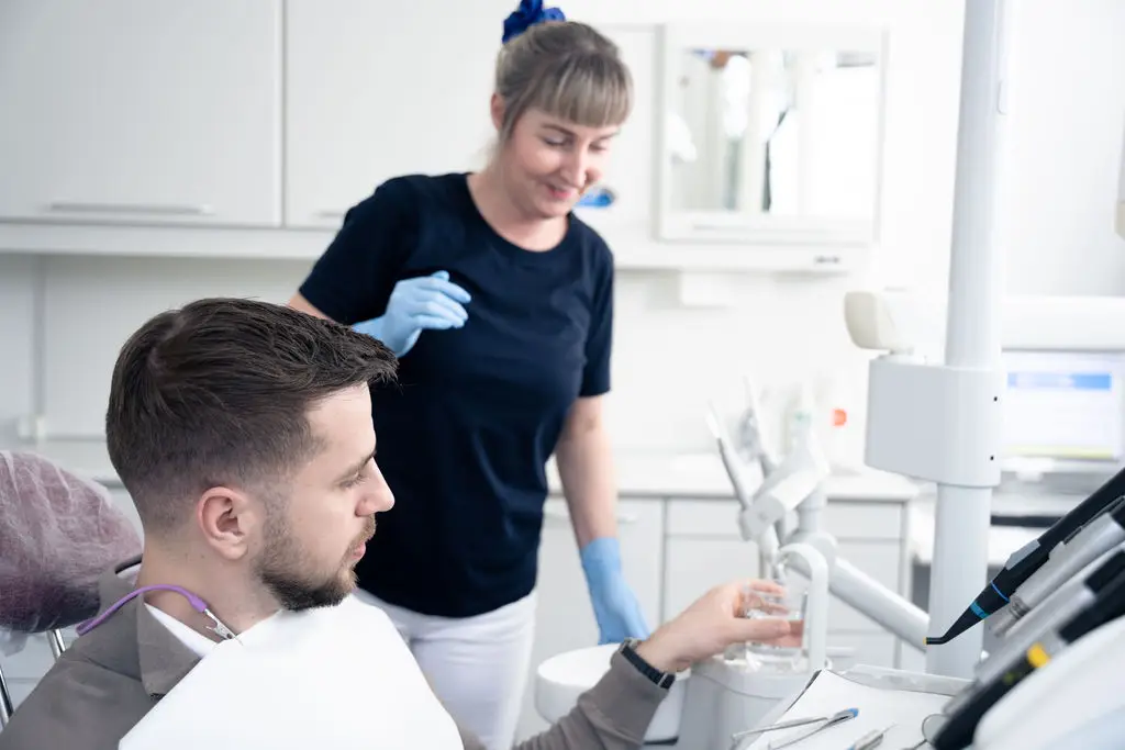 Mandlig patient får vejledning ved tandlægeunit i klinik på Amager