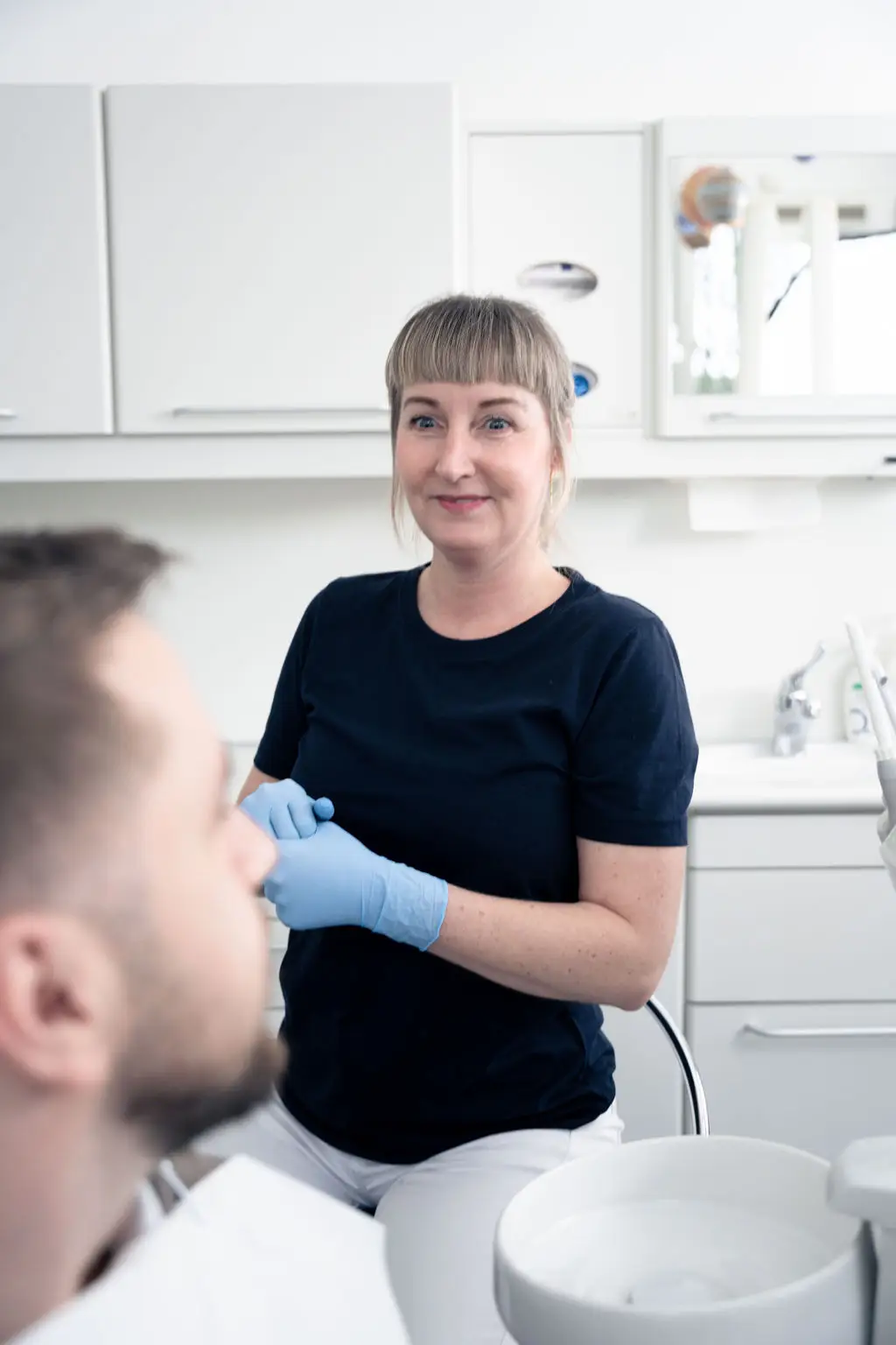 Tandplejeren skaber en afslappet og imødekommende stemning inden behandlingen begynder.