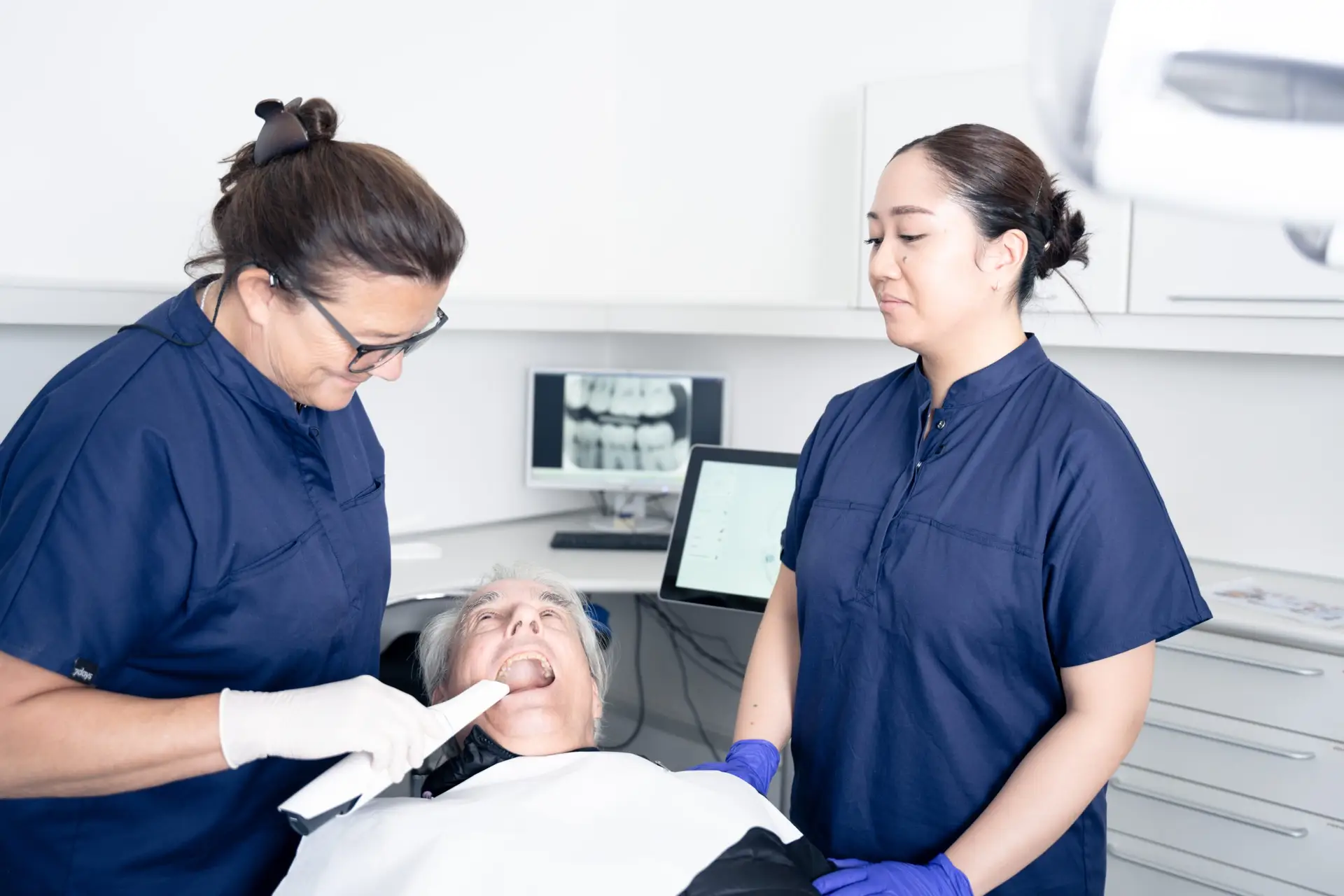 To klinikassistenter samarbejder i behandlingsrum hos tandlæge på Amager