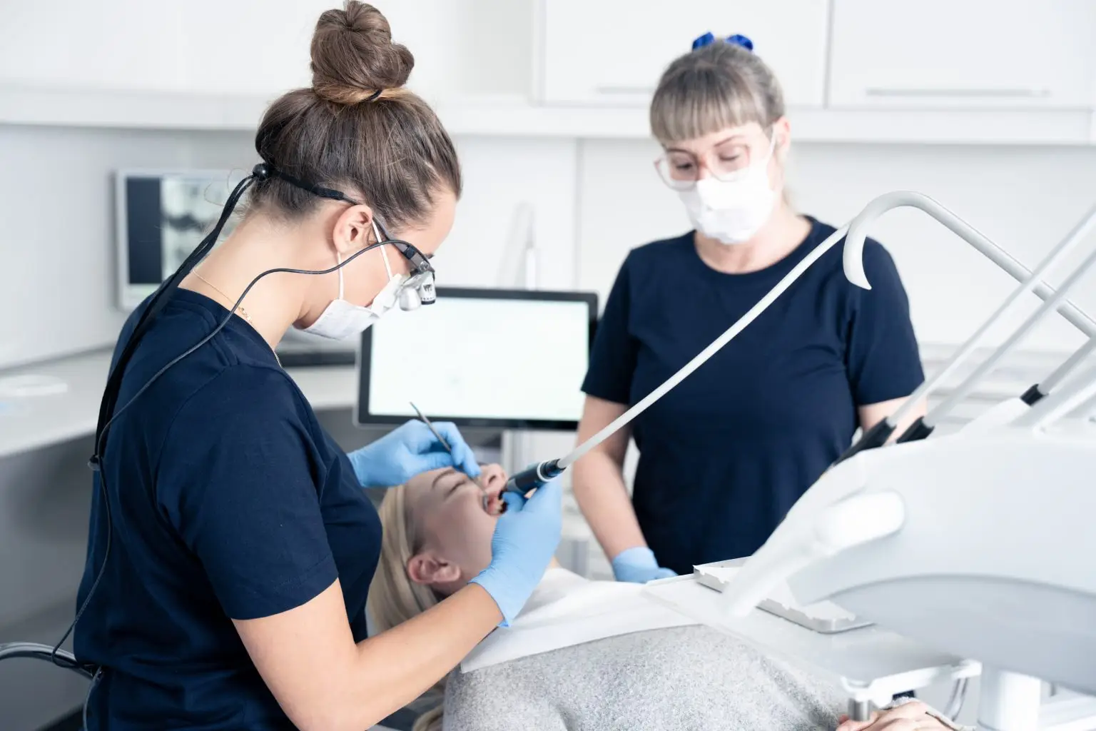 Tandlægen og klinikassistenten arbejder tæt sammen under behandlingen.