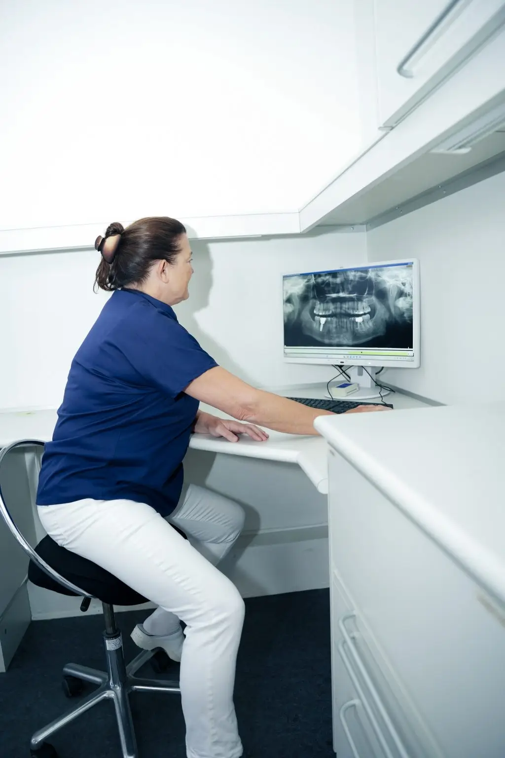 Tandlægen analyserer det digitale panoramabillede for at vurdere knogler, implantater eller tandstilling.