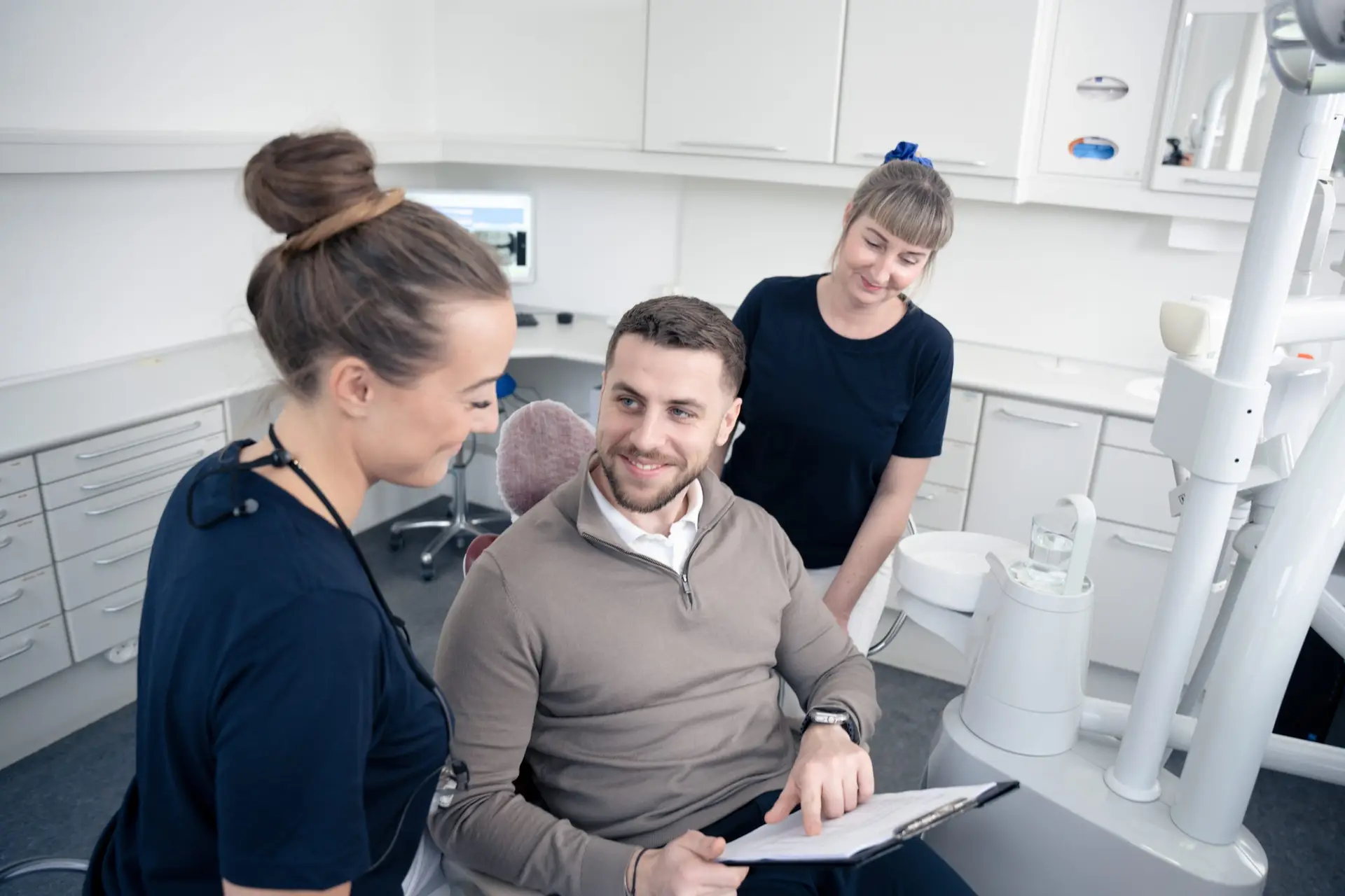 Patient og personale gennemgår information efter behandling hos tandlæge på Amager