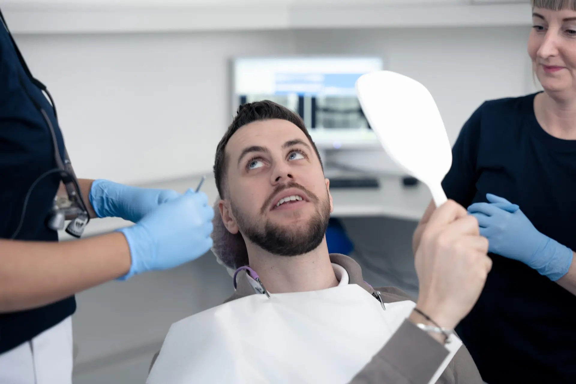 Mandlig patient til undersøgelse hos tandlægerne Ølandshus på Amager. Patienten sidder i tandlægestol med røntgenbillede i baggrunden.