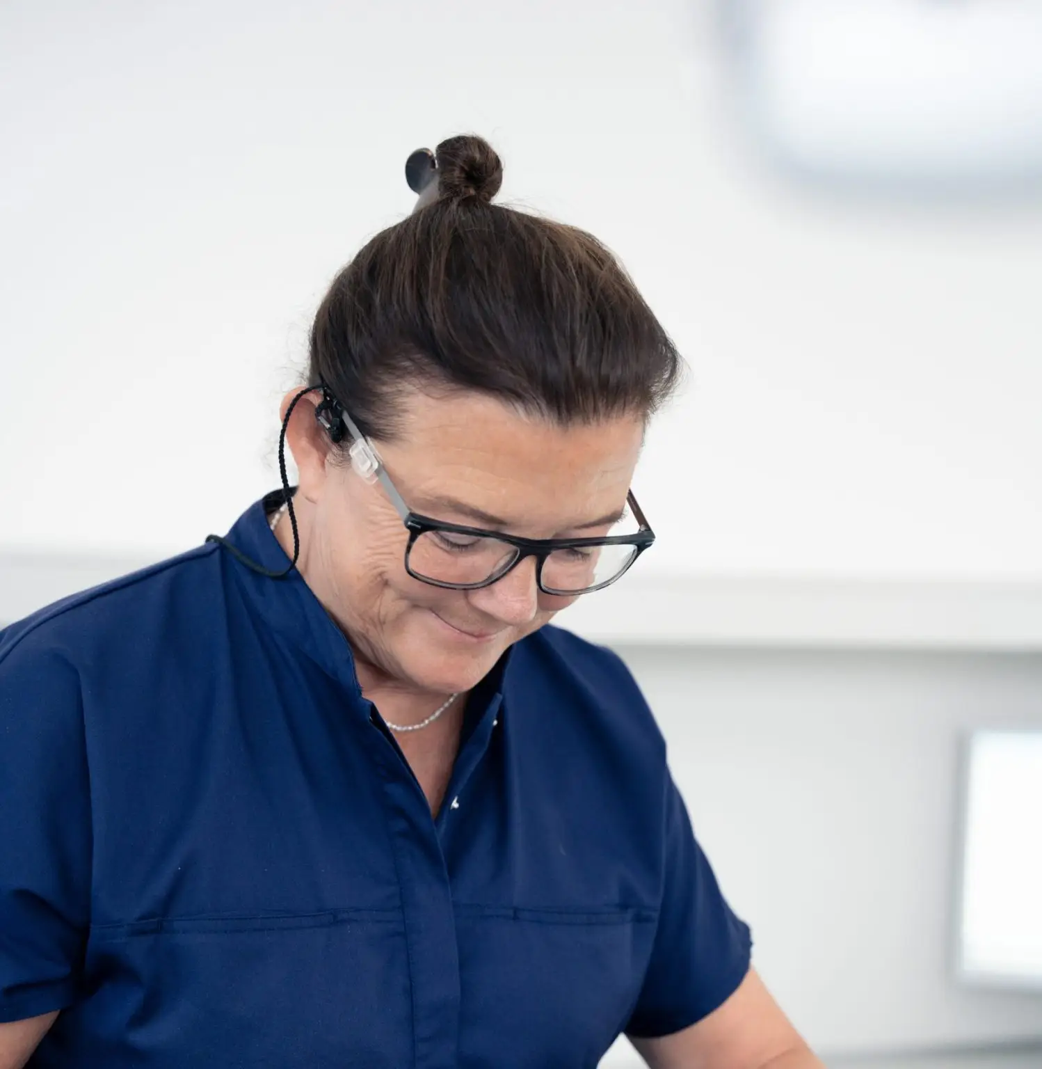 Smilende tandlæge hos tandlægerne Ølandshus på Amager iført kliniktøj.