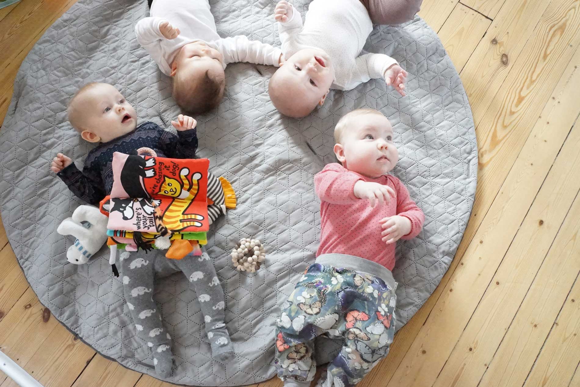 4 babyer ligger på det multifunktionelle legetæppe, til mødregruppe hygge