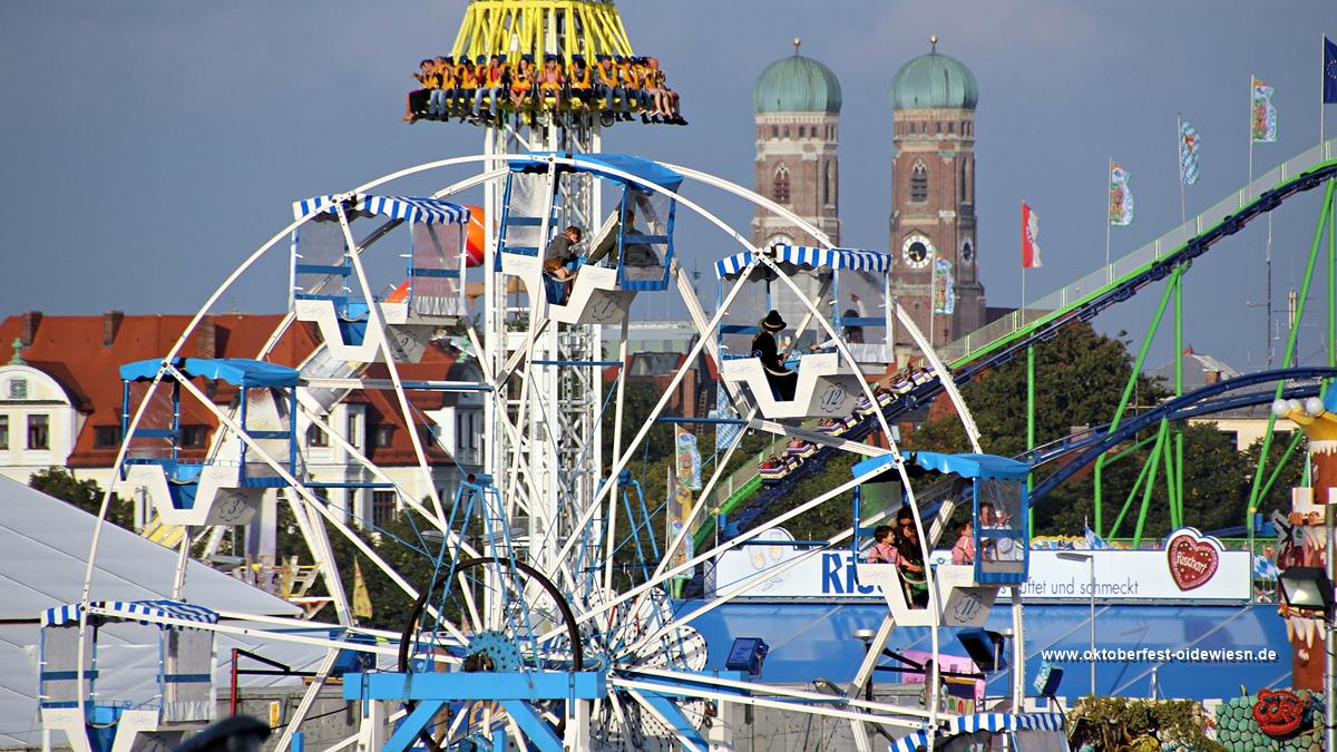 Oide Wiesn im Vordergrund - Oktoberfest Fahrgeschäfte im Hintergrund