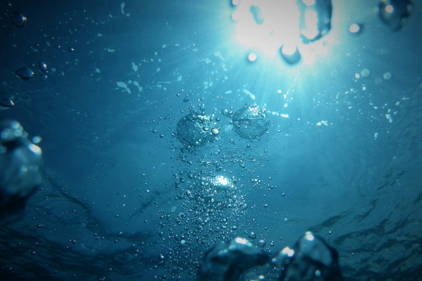 Bilde av vann sett nedenfor med et kraftig lys over. Bobler formeres i vannet.