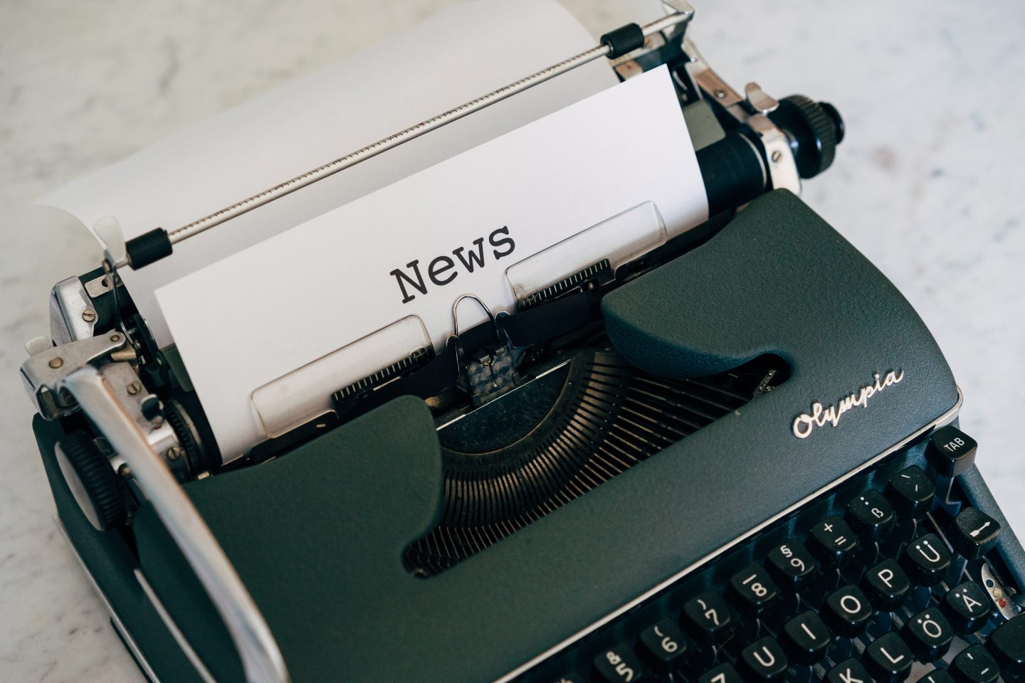 En skrivemaskin med et ark der det er skrevet "News".