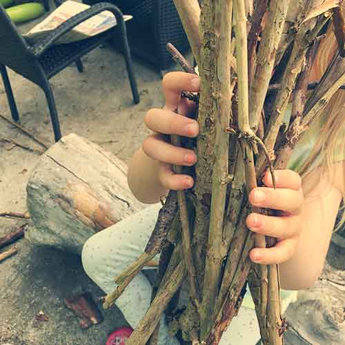 Hands filled with kindling for the campfire