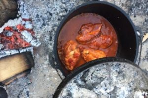 cooking chicken in a dutch oven over fire