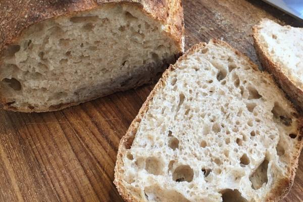 A slice of bread with big air bubbles and a thick crust.