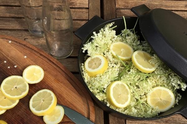 Elder flowers and lemons in a cast iron pot, ready for making elderflower cordial