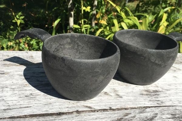 Two KUPILKA sustainable cups on a wooden table