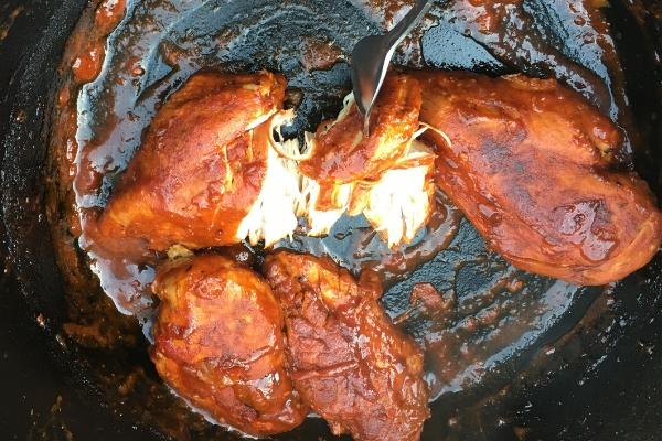 3 pieces of Chicken cooked so that it pulls apart with a fork - still inside the pot where it was cooked.