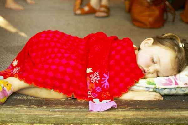 Toddler sleeping on a small matress with a blanket