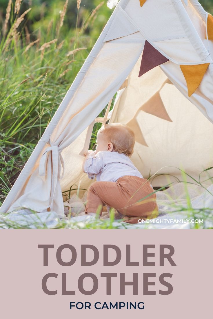 Toddler looking out from a tepee outdoors