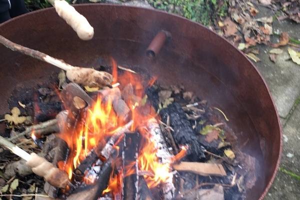 breads on sticks over a campfire