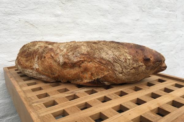 Bread on wooden surface with a white brick background