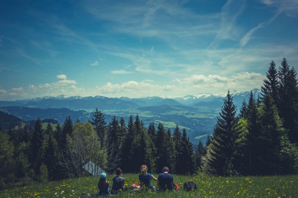 Family sitting in the grass on a mountain top