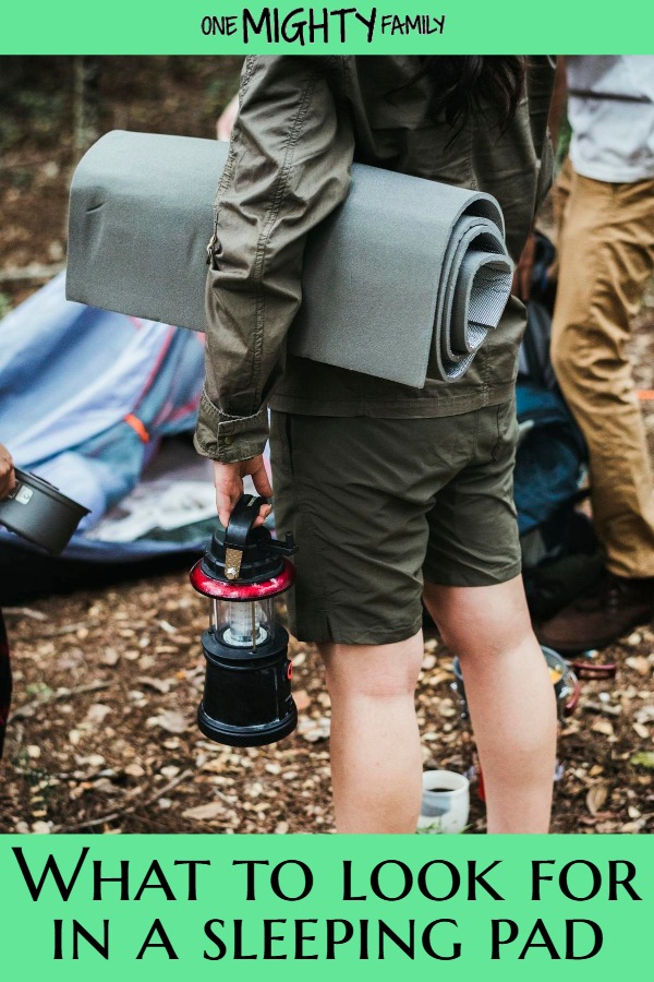 a picture of people with a rolled up sleeping pad and a campsite, and the caption "what to look for in a sleeping pad"