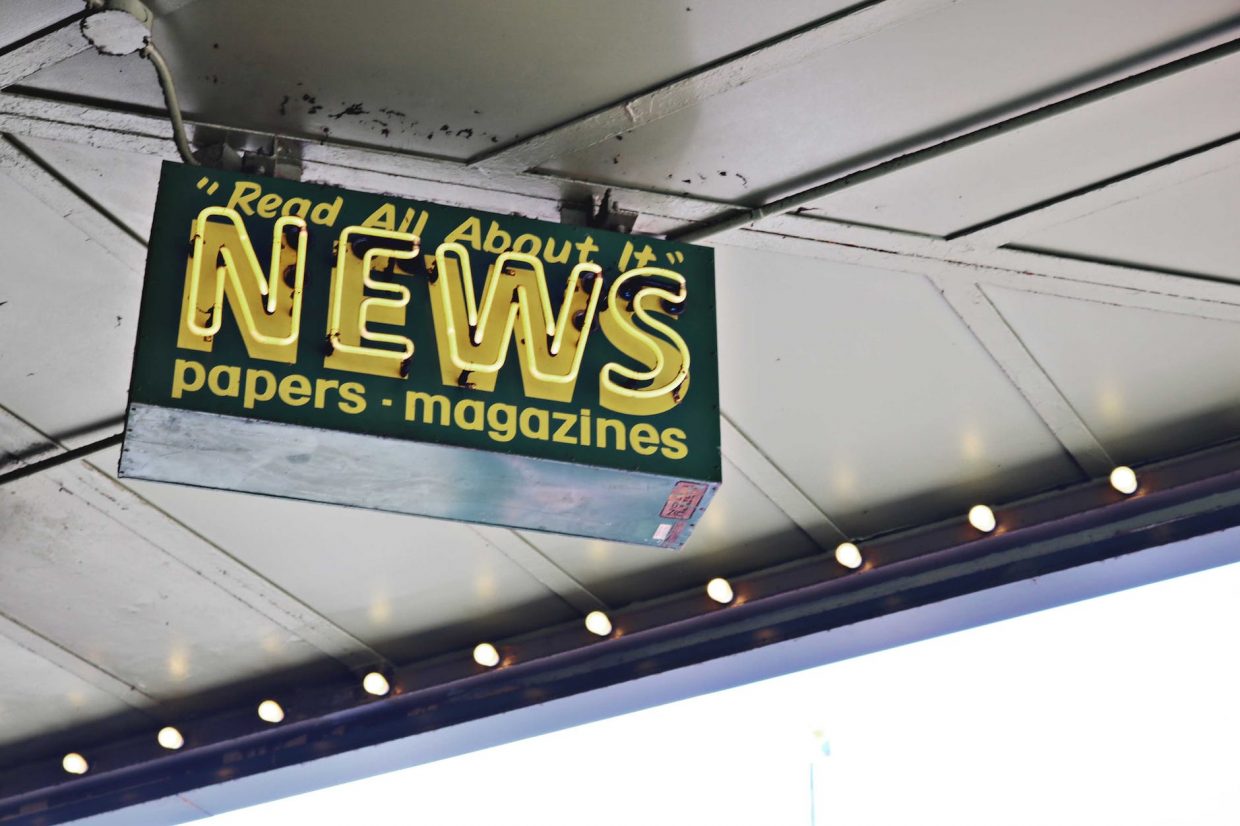 news inscription on neon signboard hanging on street