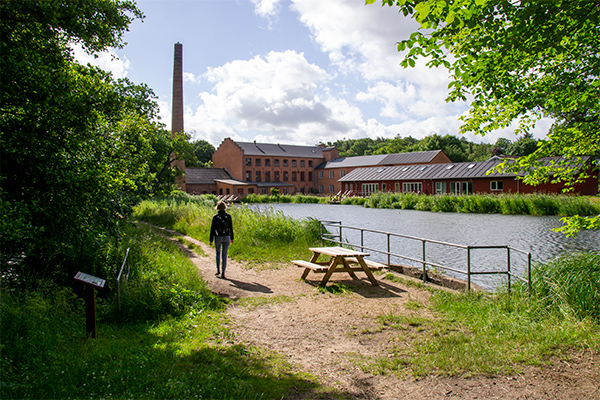 Fabriksbygningerne ved Bruunshåb ligger idyllisk ved den opstemmede møllesø.