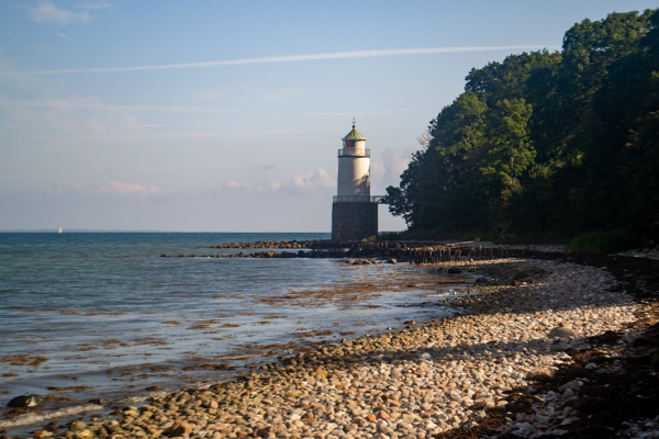 Taksensand Fyr står smukt på stranden i den sydlige ende af skoven.