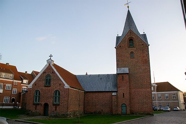 Byens kirke er opført i 1400-tallet og befinder sig lige bag torvet.