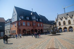 Markedspladsen er flankeret af en perlerække af farverige, gotiske bygningsværker.