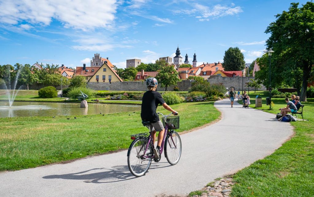 En gutt sykler med utsikt mot Visby fra Almedalen park på Gotland