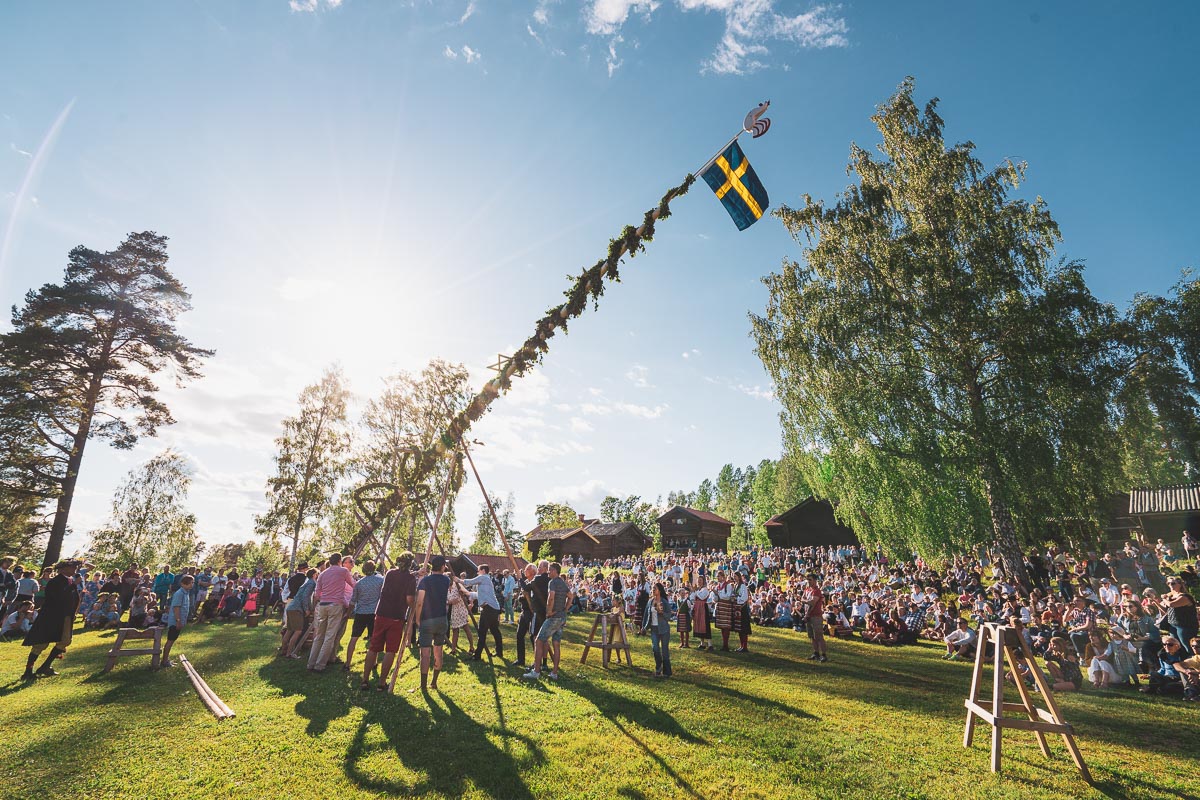 Midtsommer-viktig-fridag-helligdag-Sverige Feiring av midtsommer med heising av majstang på gammelgård i Sverige