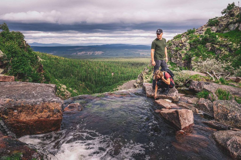 Et par drikker av brusende elv i fjellet i nasjonalpark i Dalarna