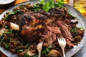 Pulled lam opskrift med saftigt lammekød serveret på fad med krydderurter