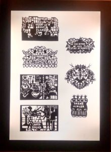 Eksempler på papirklip i sort, udstillet i lyspanel på Papirmuseet i Silkeborg