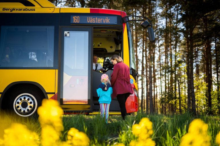 Personer går på en gul KLT-buss